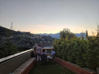 a group of people sitting on a terrace of a house at La Cabane Charmant T2 avec jardin centre village in Saint-Gervais-les-Bains