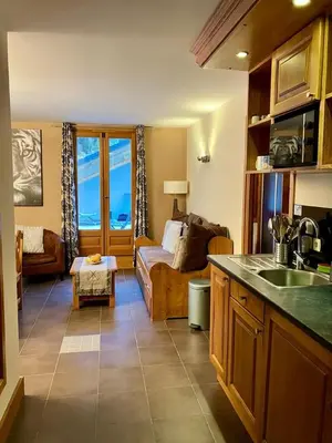 a kitchen with a living room with a couch at Cozy comfort, pool and spa close to Mont Blanc in Vallorcine