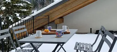 a table with a tray of food on a balcony at Cozy comfort, pool and spa close to Mont Blanc in Vallorcine