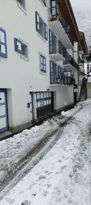 a snow covered street in front of a building at Cozy comfort, pool and spa close to Mont Blanc in Vallorcine