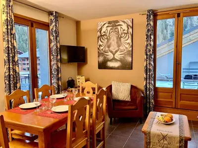 a dining room with a table and a tiger picture on the wall at Cozy comfort, pool and spa close to Mont Blanc in Vallorcine