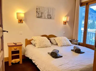 a bedroom with a bed with two hats on it at Cozy comfort, pool and spa close to Mont Blanc in Vallorcine