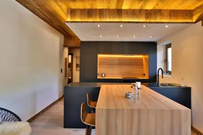 a kitchen with a wooden table and a counter at Stunning luxury apartment in Megève