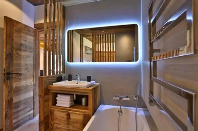 a bathroom with a tub and a sink and a mirror at Stunning luxury apartment in Megève