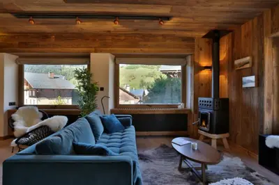 a living room with a blue couch and a fireplace at Stunning luxury apartment in Megève