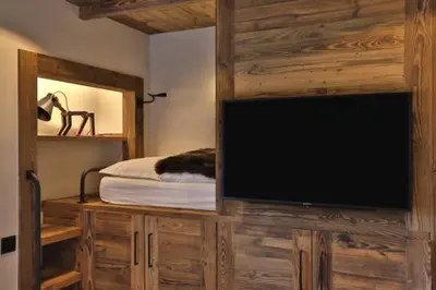 a tv on a wooden wall in a bedroom at Stunning luxury apartment in Megève