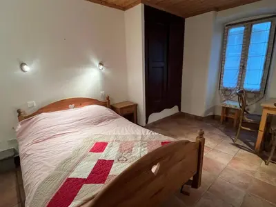 a bedroom with a bed with a quilt on it at Appartement au cœur de Samoëns – 3 chambres, 2 sdb, parking inclus - FR-1-629-143 in Samoëns