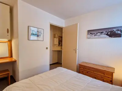 a bedroom with a bed and a dresser and a mirror at Appartement spacieux 6 pers, balcon, Flaine centre - FR-1-425-229 in Arâches-la-Frasse