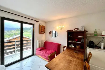 a living room with a pink couch and a table at 2-room apartment with balcony close to the slopes in Combloux