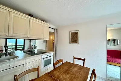 a kitchen with a table and a dining room at 2-room apartment with balcony close to the slopes in Combloux