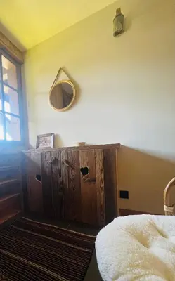 a bedroom with a wooden dresser with a mirror on the wall at Confort et Proximité in Megève