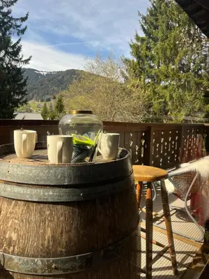 a table with cups and a glass bowl on a barrel at Confort et Proximité in Megève