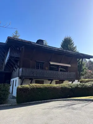 a wooden house with a porch and a balcony at Confort et Proximité in Megève