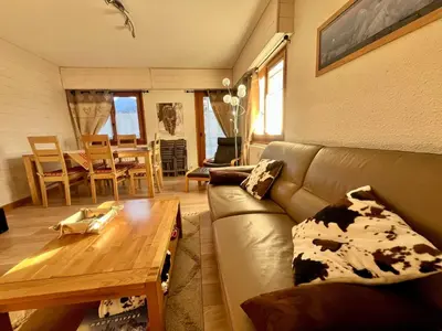 a living room with a couch and a wooden table at Appartement T3 avec 3 balcons et parking, proche centre - FR-1-624-26 in Samoëns