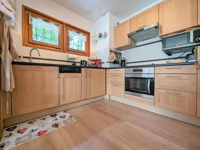 a kitchen with wooden cabinets and a sink and stove at Appartement T3 avec 3 balcons et parking, proche centre - FR-1-624-26 in Samoëns