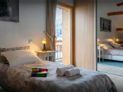 a bedroom with a bed with towels on it at Chalet Nordchamp - OVO Network in Samoëns