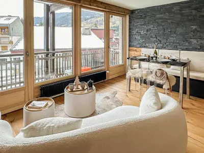a living room with a couch and a table at My Way Megeve village 5 rues parking in Megève