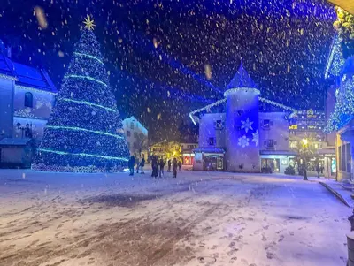 a christmas tree in a city in the snow at My Way Megeve village 5 rues parking in Megève