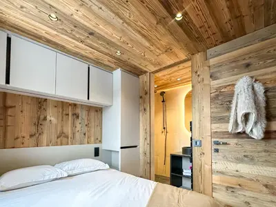 a bedroom with wooden walls and a bed with white pillows at My Way Megeve village 5 rues parking in Megève