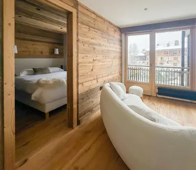 a bedroom with a bed and a couch in a room at My Way Megeve village 5 rues parking in Megève