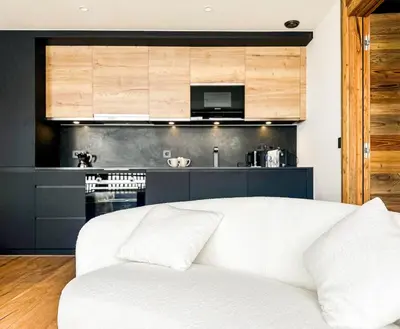a white couch in a living room with a kitchen at My Way Megeve village 5 rues parking in Megève