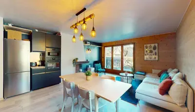a kitchen and living room with a table and a couch at Bright, warm 2BR 2min to gondola, private garden in Chamonix-Mont-Blanc