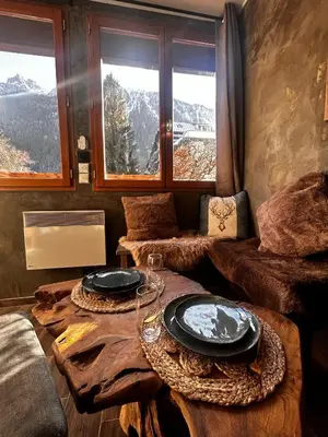 a living room with two tables with plates on them at Jonquille 2 - Centre - Terrasse Privee - Vues in Chamonix-Mont-Blanc