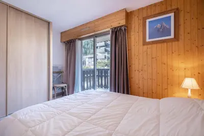 a bedroom with a large white bed and a window at Beautiful 50m with 2 balconies and mountain view in Chamonix-Mont-Blanc