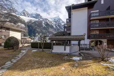 a apartment building with mountains in the background at Beautiful 50m with 2 balconies and mountain view in Chamonix-Mont-Blanc
