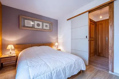 a bedroom with a white bed and a closet at Beautiful 50m with 2 balconies and mountain view in Chamonix-Mont-Blanc