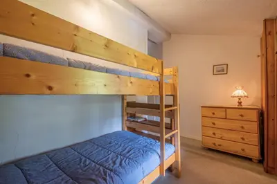 a bedroom with two bunk beds and a dresser at Cozy big Chalet with Spectacular Mont-Blanc View in Chamonix-Mont-Blanc