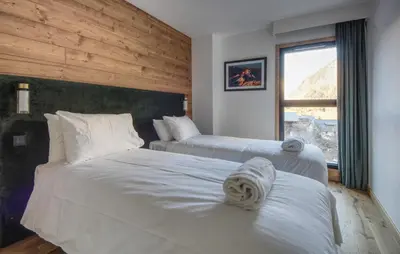 a hotel room with two beds and a window at Apartment Aiguille Rose in Les Houches
