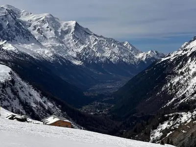 a snow covered mountain range with a ski lodge on a slope at Apartment Aiguille Rose in Les Houches