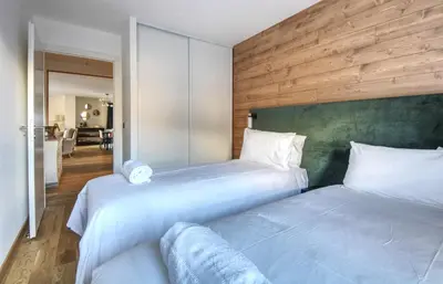 a bedroom with two beds and a hallway with a room at Apartment Aiguille Rose in Les Houches