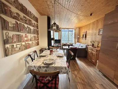 a dining room with a table and a living room at Appartement 2 Pièces + Coin Nuit, 4-6 Couchages avec Balcon et Parking à Megève - FR-1-597-191 in Megève