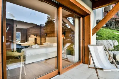 a room with a view of a bedroom through glass at Les Carlines 01 in Samoëns