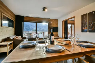 a dining room with a table with wine glasses at Les Carlines 01 in Samoëns