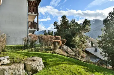 a house on a hill with a yard with rocks at Les Carlines 01 in Samoëns