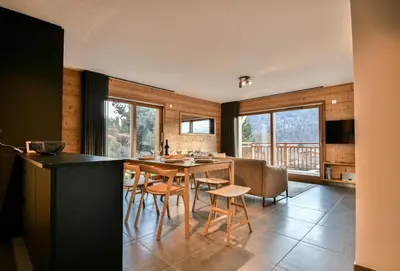 a kitchen and dining room with a table and chairs at Les Carlines 01 in Samoëns