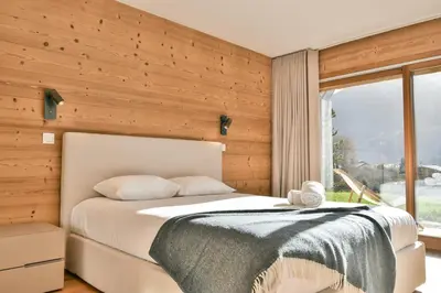 a bedroom with a bed and a window at Les Carlines 01 in Samoëns