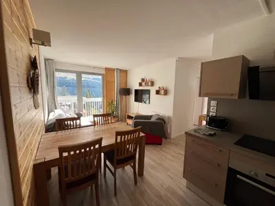 a kitchen and living room with a table and chairs at appartement petite ourse flaine 2chambres avec wifi in Flaine
