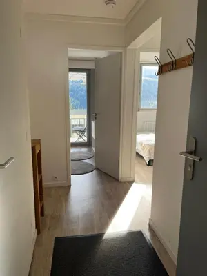 a hallway with a room with a bed and a window at appartement petite ourse flaine 2chambres avec wifi in Flaine