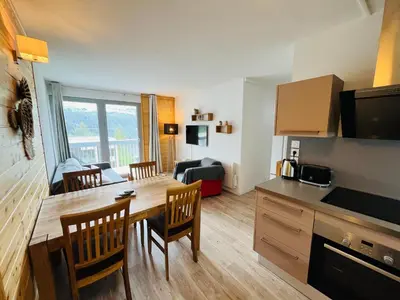 a kitchen and living room with a table and chairs at appartement petite ourse flaine 2chambres avec wifi in Flaine