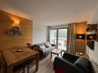 a living room with a couch and a table at appartement petite ourse flaine 2chambres avec wifi in Flaine