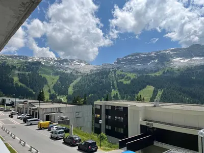 a parking lot with cars parked in front of a mountain at appartement petite ourse flaine 2chambres avec wifi in Flaine