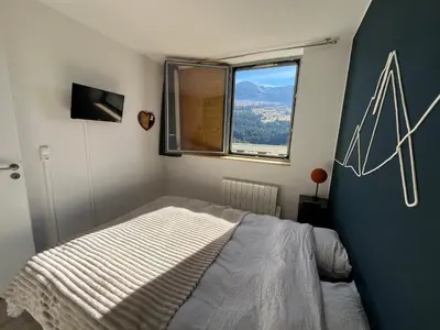 a bedroom with a bed and a window at appartement petite ourse flaine 2chambres avec wifi in Flaine