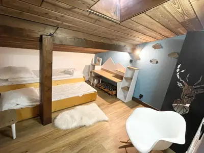 a room with two bunk beds and a desk at Duplex départ randonnée Megeve in Demi-Quartier