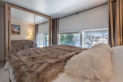 a bedroom with a large bed with a large window at Beautiful Apt near the Grands Montets slopes in Chamonix-Mont-Blanc