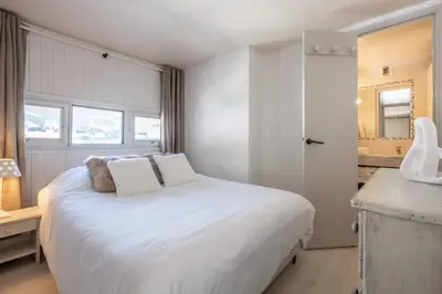 a white bedroom with a white bed and a bathroom at Beautiful Apt near the Grands Montets slopes in Chamonix-Mont-Blanc