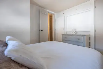 a white bedroom with a bed and a dresser at Beautiful Apt near the Grands Montets slopes in Chamonix-Mont-Blanc